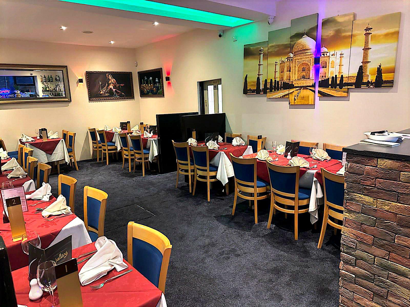 Jaflong dining room with Taj Mahal artwork, red tablecloths and green ambient lighting