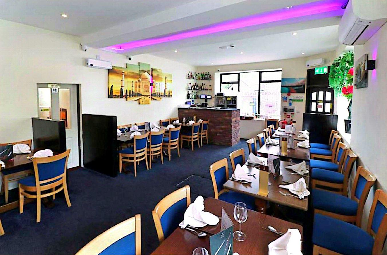 Jaflong dining room with laid tables, blue chairs and purple ambient lighting