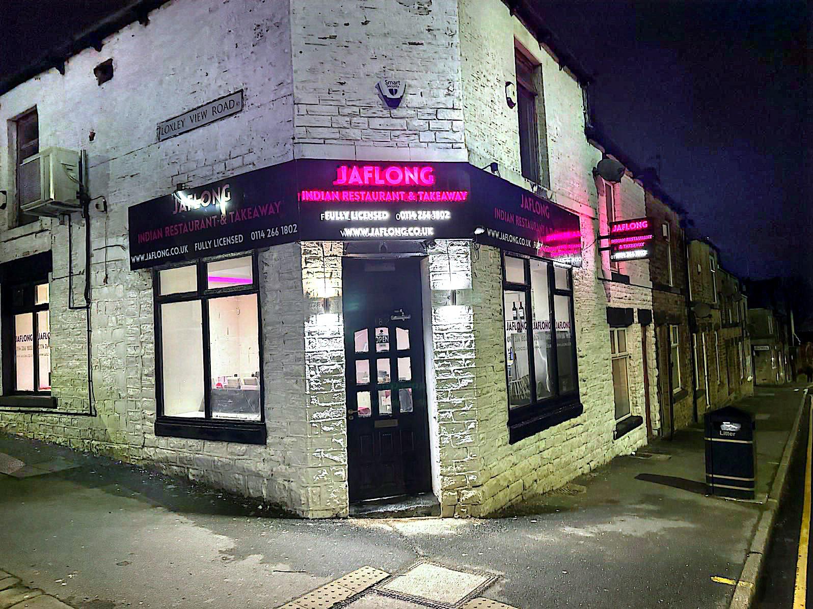 Jaflong restaurant exterior at night with illuminated pink signage